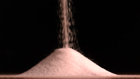Sugar-pouring-on-black-background