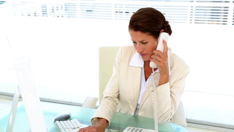 Geschäftsfrau,-Die-An-Ihrem-Schreibtisch-Arbeitet-Und-Das-Telefon-Beantwortet