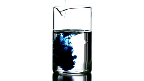 Drops-of-blue-liquid-falling-into-beaker