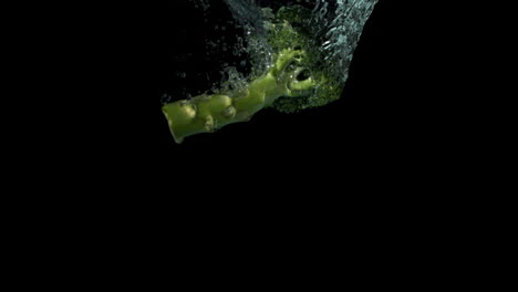 Broccoli-falling-in-water-on-black-background