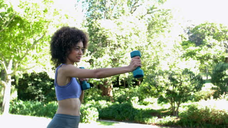Fit-brunette-working-out-with-dumbbells-in-the-park