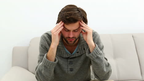 Young-depressed-man-sitting-on-sofa-