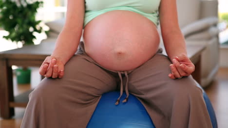 Mujer-Embarazada-Sentada-Sobre-Una-Pelota-De-Ejercicio-Azul