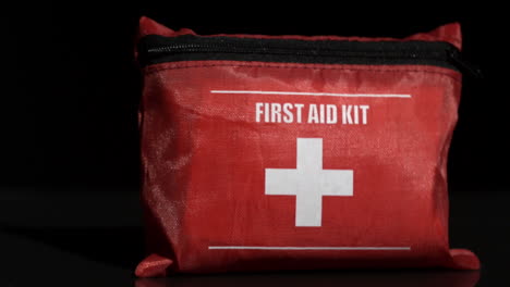 Erste-Hilfe-Kit-Fällt-Auf-Schwarzem-Hintergrund