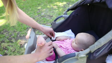 Mutter-Kümmert-Sich-Um-Ihr-Kleines-Mädchen-Im-Kinderwagen-Im-Park