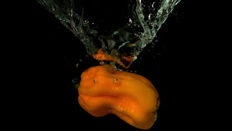 Chili-pepper-falling-in-water-on-black-background