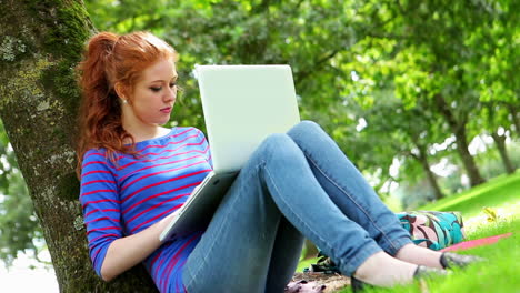 Studentin-Sitzt-An-Einem-Baum-Und-Benutzt-Ihren-Laptop