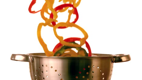 Pepper-slices-falling-into-colander