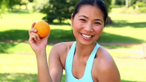 Fit-Asiatische-Mädchen-Zeigt-Eine-Orange-