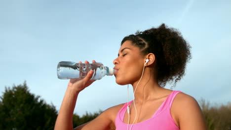 Fit-woman-drinking-water-after-jogging-outside