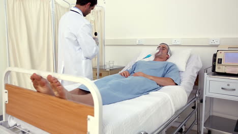 Doctor-checking-patient-in-bed-with-an-oxygen-mask