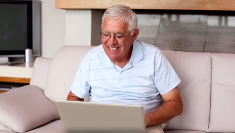 Senior-man-using-laptop-on-couch