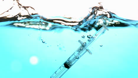 Syringe-falling-into-blue-water
