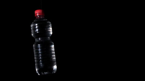 Botella-De-Plástico-Girando-Sobre-Superficie-Negra