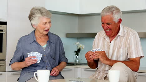 Senior-couple-playing-cards-at-the-counter