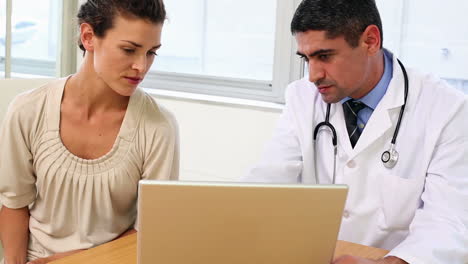 Doctor-speaking-with-his-patient-at-desk