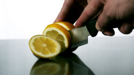 Man-slicing-lemon-with-large-knife