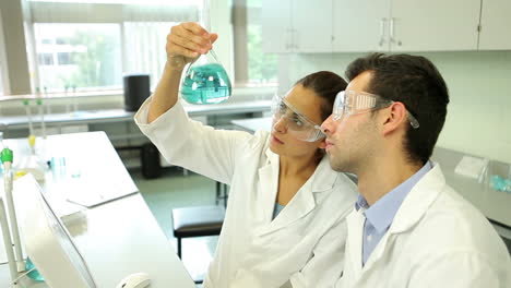 Estudiantes-De-Ciencias-Mirando-Juntos-La-Sustancia-Química-Azul-Usando-La-Computadora