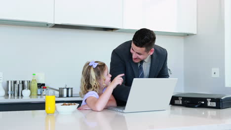 Father-using-the-laptop-with-his-daughter-before-work