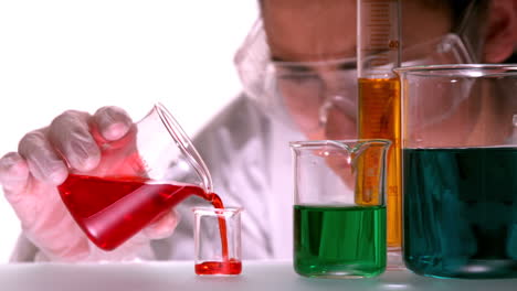 Scientist-pouring-red-liquid-into-beaker