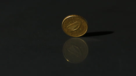 Euro-coin-spinning-on-black-surface