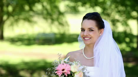 Beautiful-bride-smiling-at-camera-in-the-park