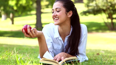 Linda-Chica-Tirada-En-El-Pasto-Leyendo-Un-Libro