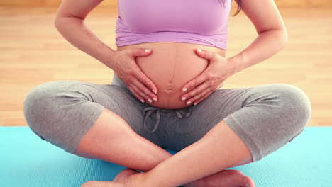 Pregnant-woman-sitting-on-exercise-mat
