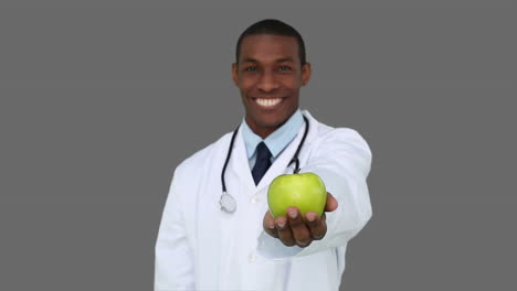 Glücklicher-Junger-Arzt-Zeigt-Kamera-Einen-Apfel