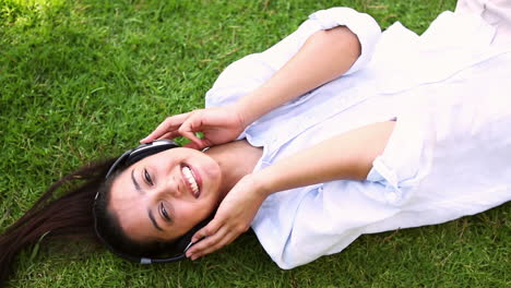 Pretty-girl-lying-on-the-grass-listening-to-music