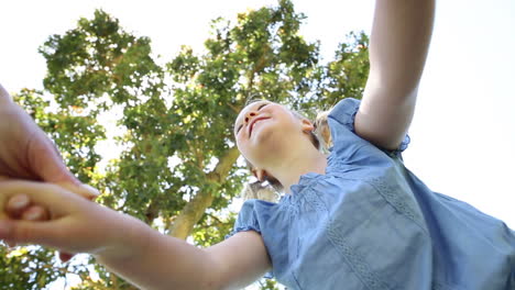 Glückliches-Kleines-Mädchen-Dreht-Sich-Mit-Mutter-Im-Park