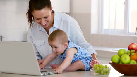 Hübsche-Mutter-Mit-Laptop-Und-Spielt-Mit-Baby