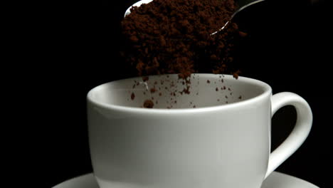 Teaspoon-pouring-granulated-coffee-into-cup