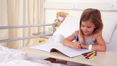 Little-girl-sitting-in-hospital-bed-colouring