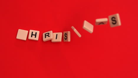 Letter-tiles-moving-to-spell-out-christmas-on-red-background