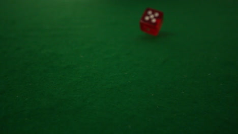 Red-dice-rolling-towards-camera-on-casino-table