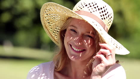Happy-girl-wearing-a-straw-hat-smiling-at-camera