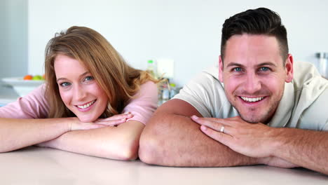 Happy-couple-leaning-on-the-counter-smiling-at-camera