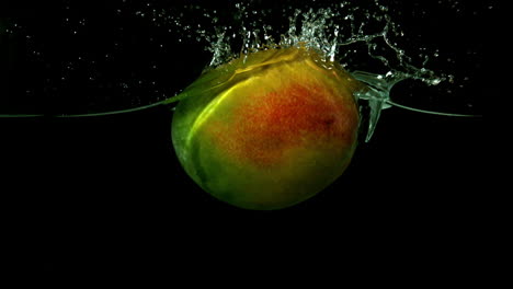 Mango-falling-in-water-on-black-background