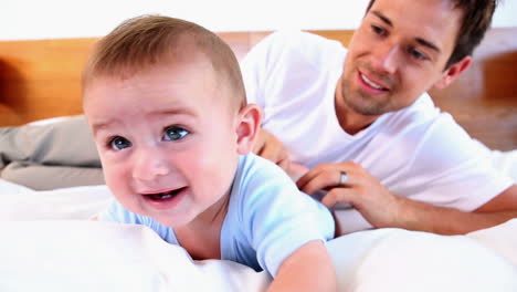 Padre-Feliz-Haciéndole-Cosquillas-A-Su-Hijo-En-La-Cama