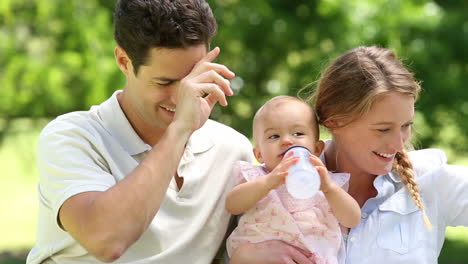 Happy-parents-with-their-baby-girl-in-the-park