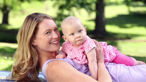 Happy-mother-playing-with-her-baby-girl-in-the-park