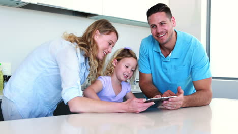 Little-girl-using-a-digital-tablet-with-her-parents