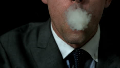 Geschäftsmann-Raucht-Seine-Zigarre-Auf-Schwarzem-Hintergrund
