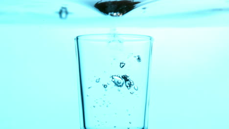 Glas-Fällt-Ins-Blaue-Wasser