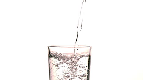 Wasser-Gießt-In-Glas-Auf-Weißem-Hintergrund