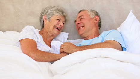 Glückliches-älteres-Paar-Liegt-Im-Bett-Und-Plaudert