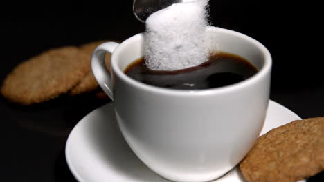 Teaspoon-pouring-sugar-into-cup-of-coffee