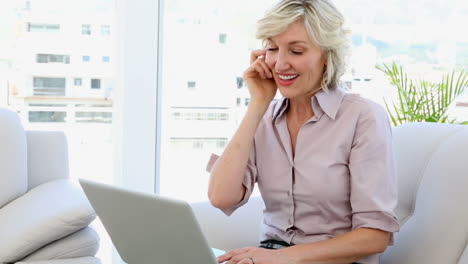 Mujer-De-Negocios-Hablando-Por-Teléfono-Y-Usando-Una-Computadora-Portátil