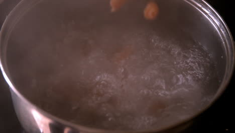 Pasta-falling-into-saucepan-of-boiling-water